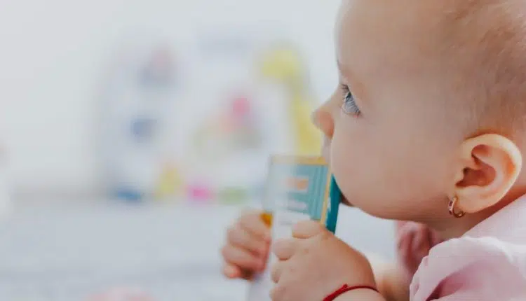 baby biting edge of book